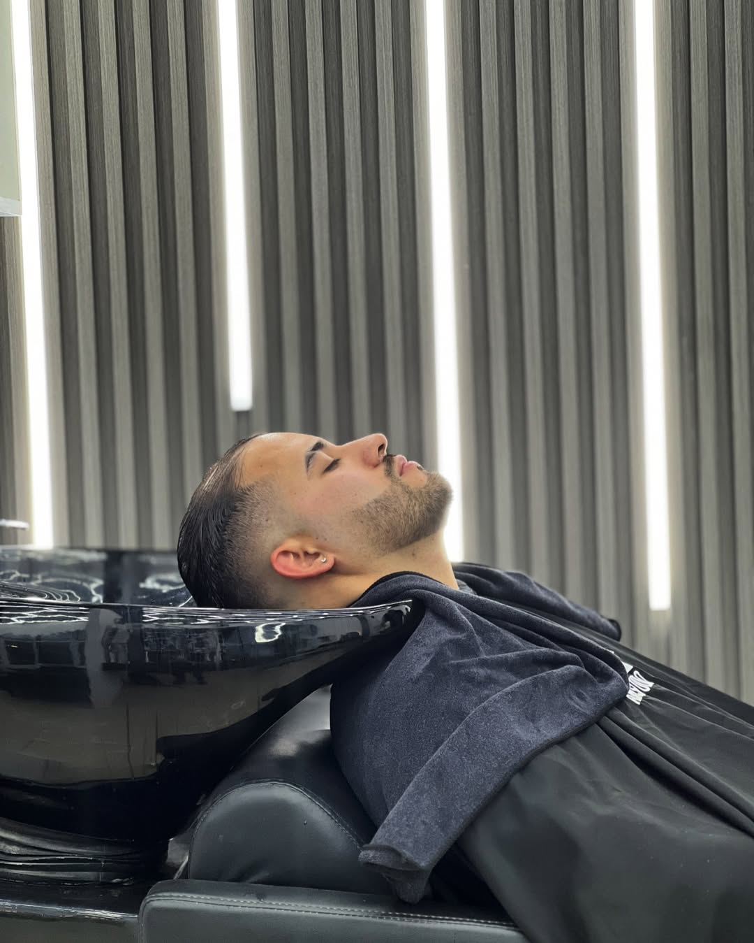 Barbero atendiendo a un cliente en AronStudio